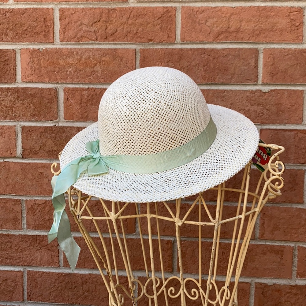 Child’s off white hat with green ribbon